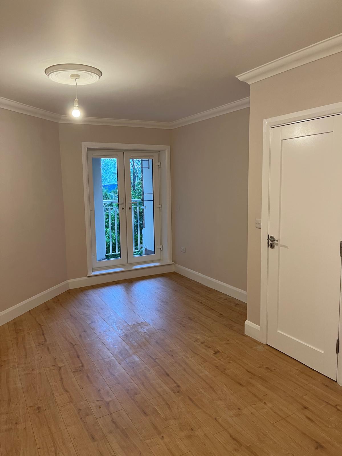 Living area restored: freshly painted walls, cornice, new laminate flooring and French doors