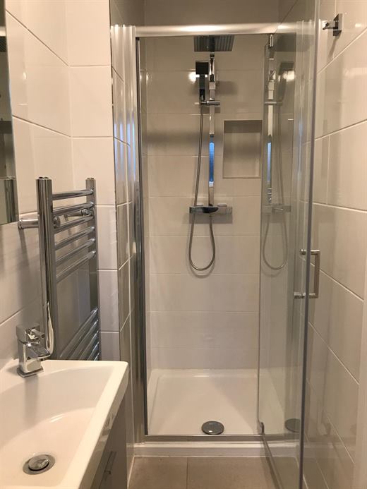 Bath and shower cubicle with white tiles