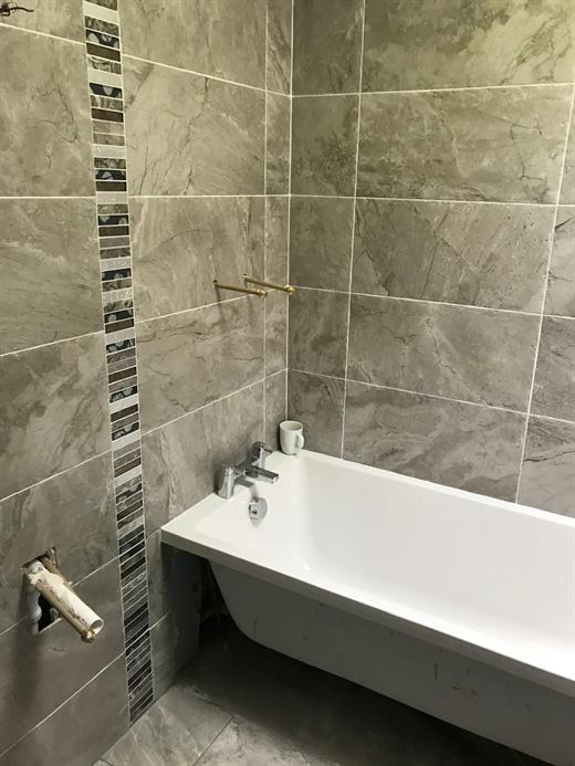 Bath with grey tiles and mosaic border