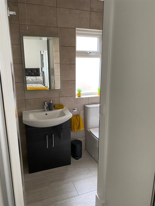 Bathroom with dark vanity unit and mirror