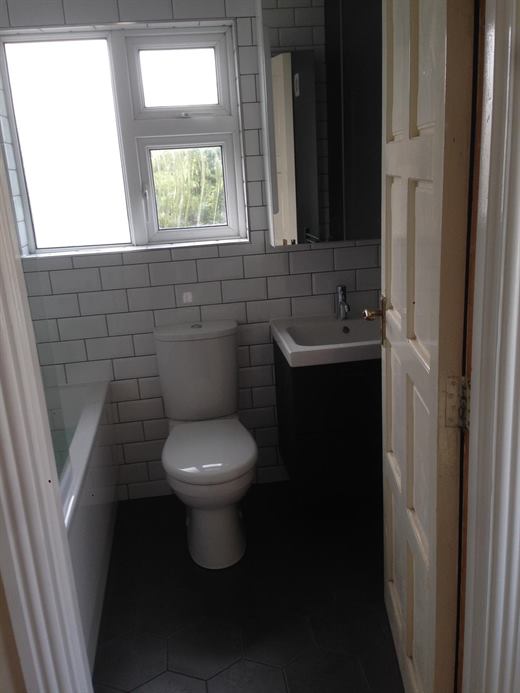 Bathroom with metro tiles, dark floor tiles and bath