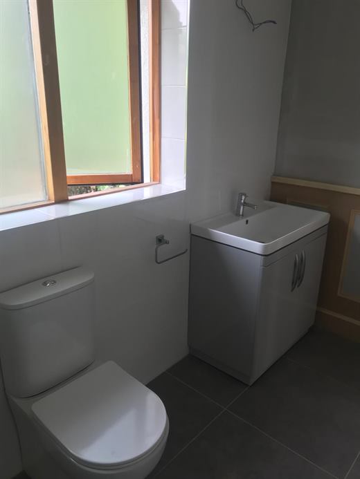 Bathroom with vanity unit, toilet and panelled wall