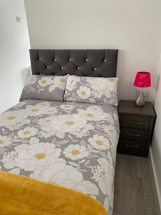 Bedroom with upholstered bed and floral bedding