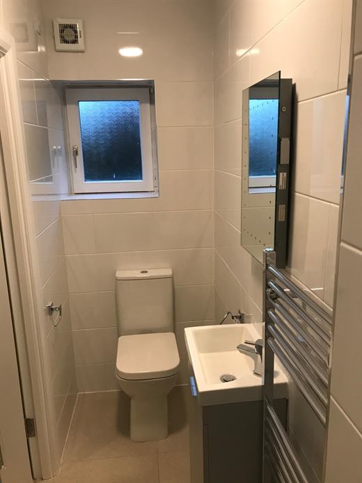 Compact bathroom with window, toilet and vanity