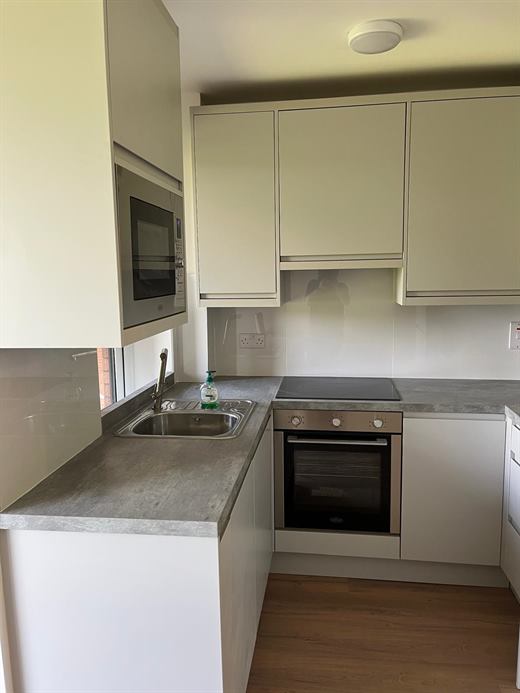 Compact kitchen with grey worktop, integrated oven and hob