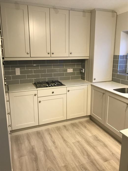 Cream shaker kitchen units with gas hob and quartz worktop