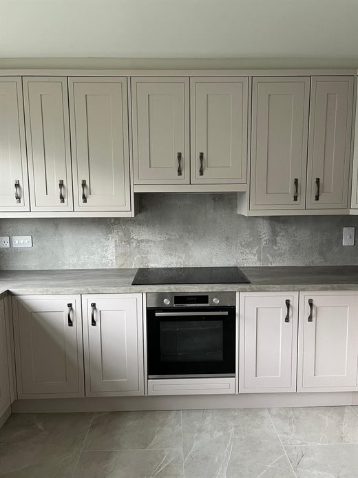Cream shaker kitchen with grey splashback and built-in oven