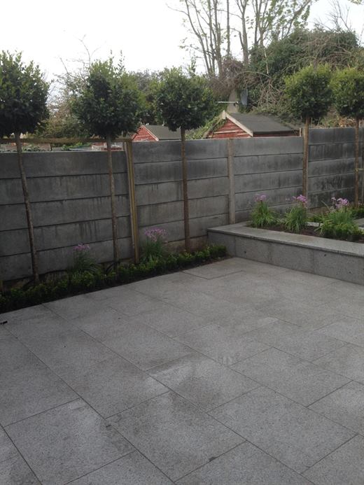 Finished granite-effect patio with raised planter