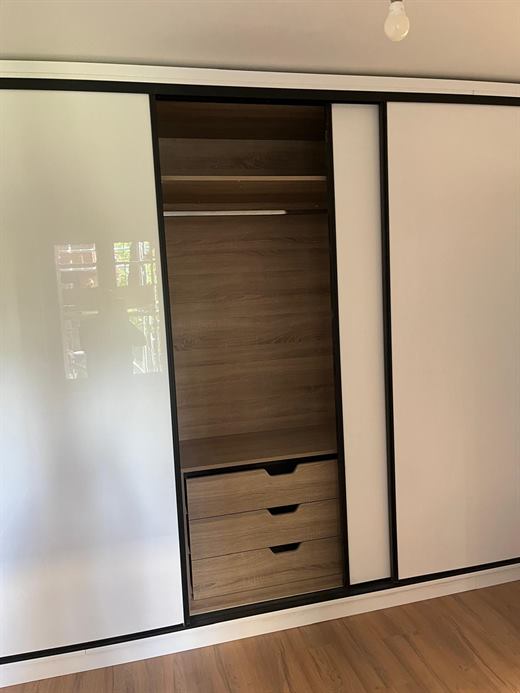 Fitted wardrobe with sliding white doors, oak-effect interior and drawers