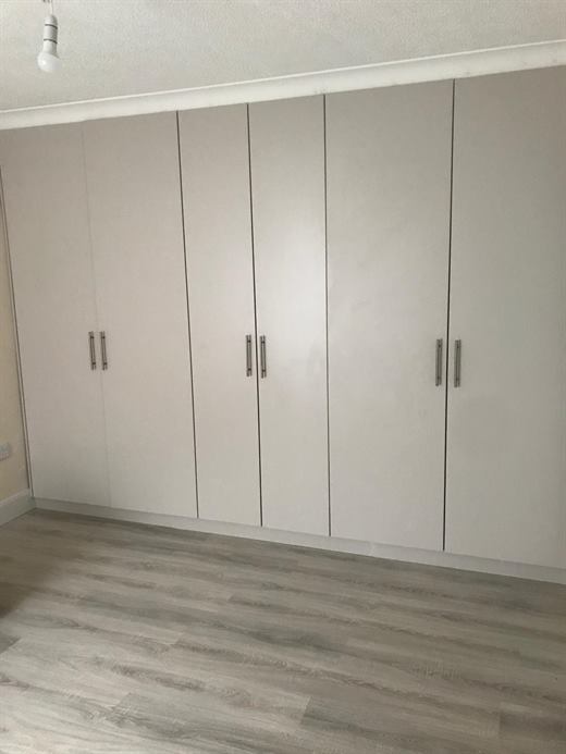 Floor-to-ceiling fitted wardrobes with handleless doors