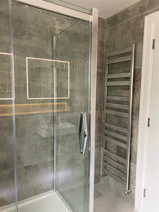 Glass shower with heated towel rail