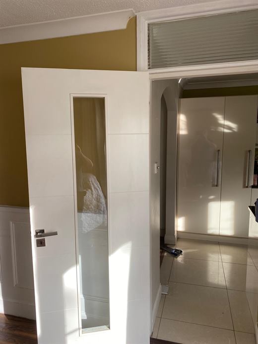 Hallway with white doors and fitted cupboards