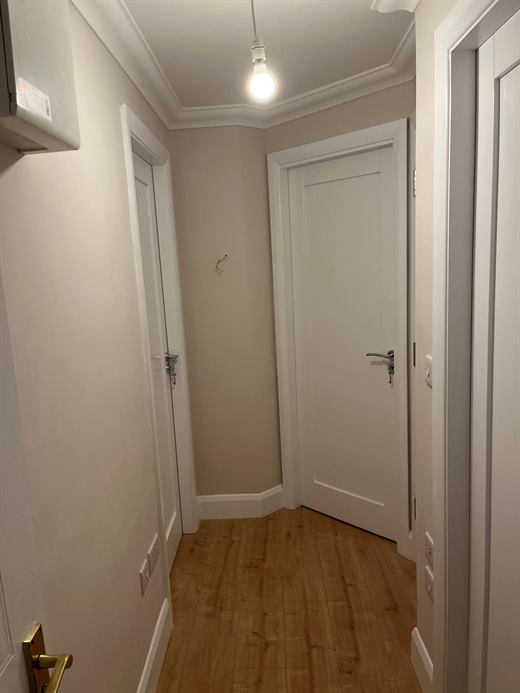 Hallway with white panelled doors and laminate flooring