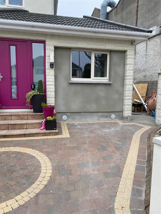 House front with pink door, new render and paved driveway