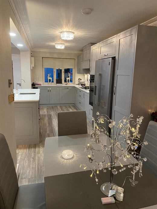 Kitchen and dining area with grey units and laminate floor