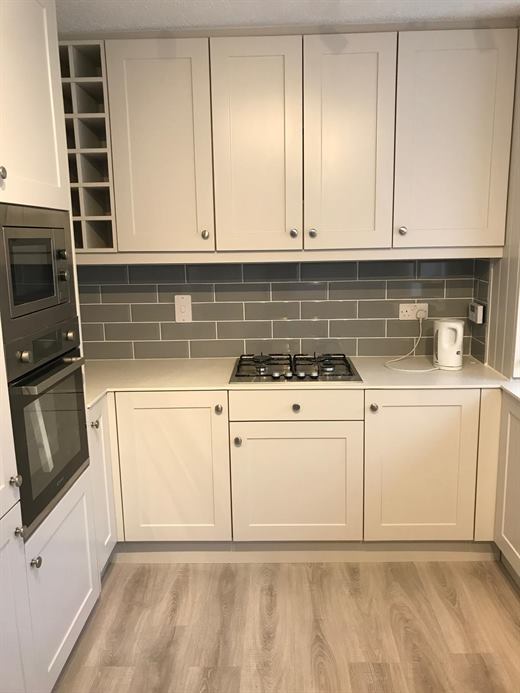 Kitchen with built-in oven and microwave and grey metro tile splashback