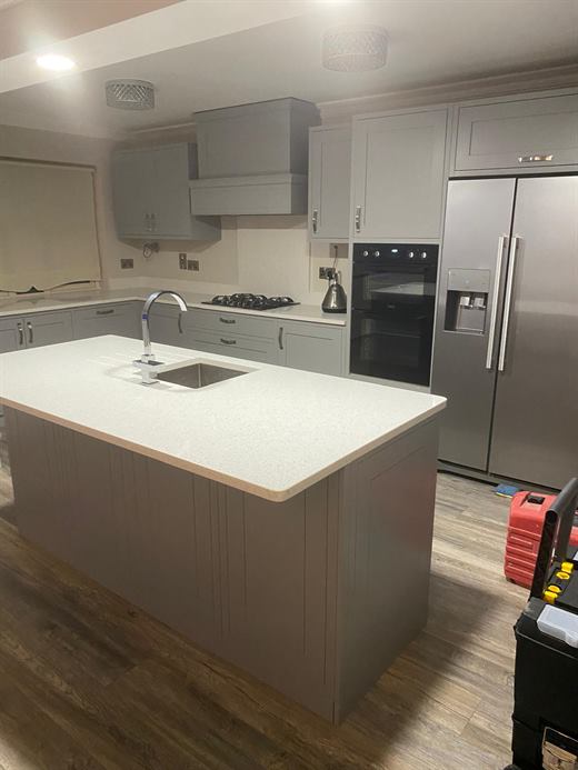 Kitchen with grey island, quartz top and American fridge freezer