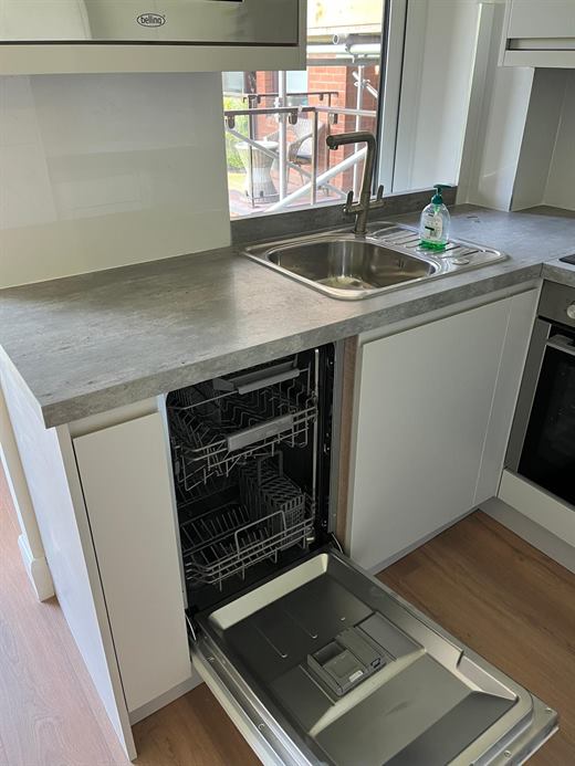 Kitchen with stainless steel sink and integrated dishwasher