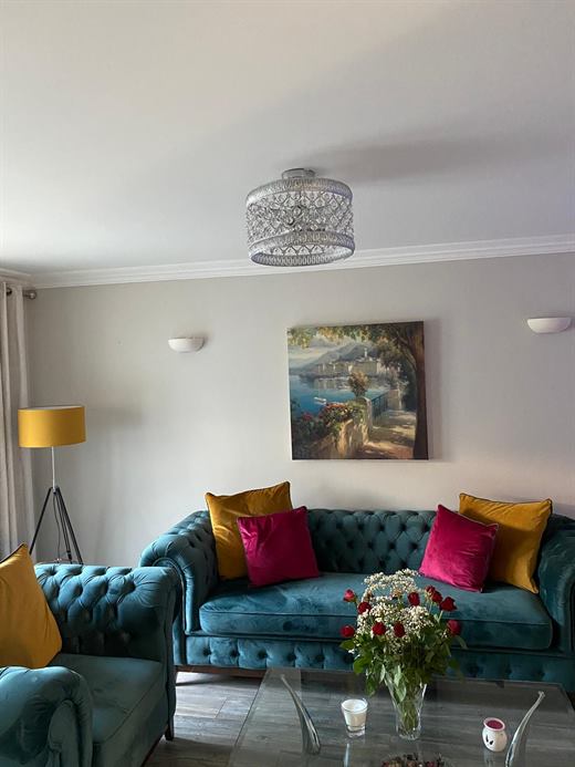 Living room with teal sofa and laminate flooring