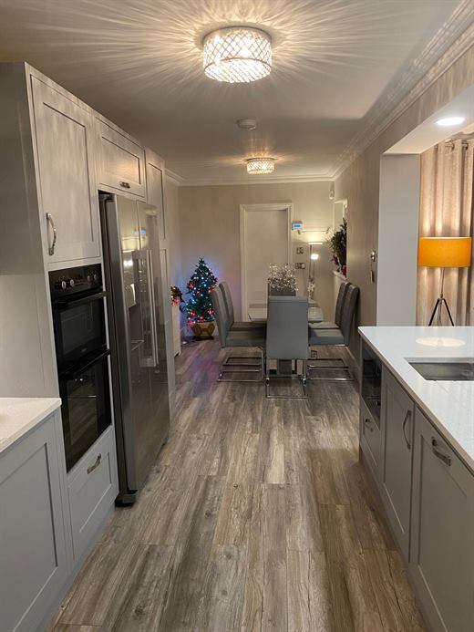 Long kitchen-diner with grey shaker units and double oven