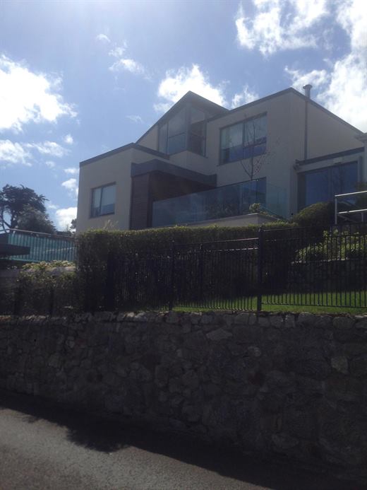 Modern house with dark render and railings
