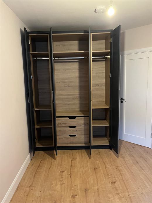 Navy fitted wardrobe with open doors showing an oak-effect interior