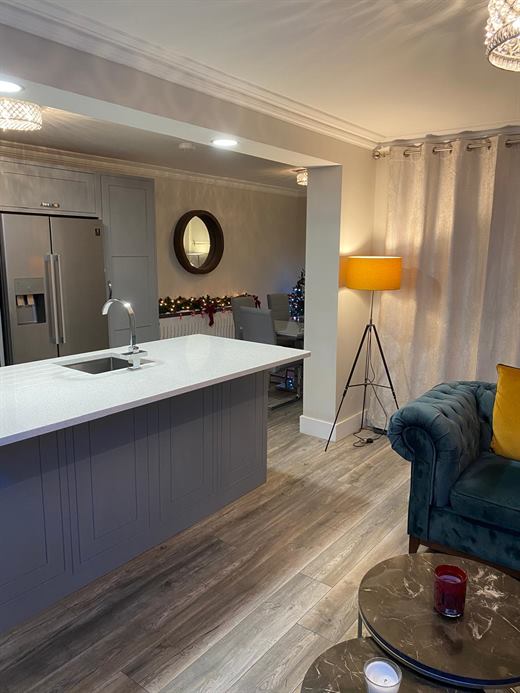 Open-plan kitchen with white-topped island and living area