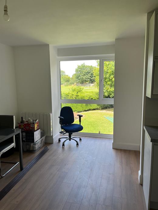 Room with large window and laminate flooring