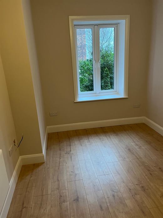 Room with window, painted walls and new laminate flooring