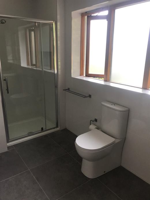 Shower room with glazed door and grey floor tiles