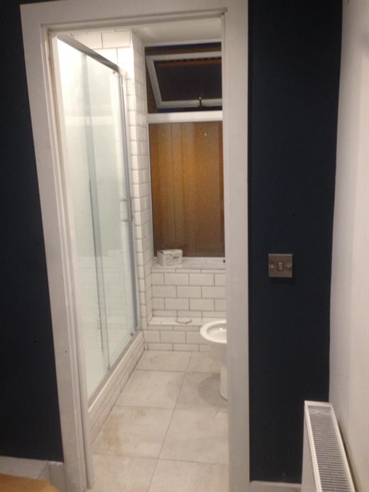 Shower room with sliding glass door and tiled floor