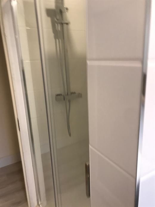 Shower with chrome fittings behind a glass screen