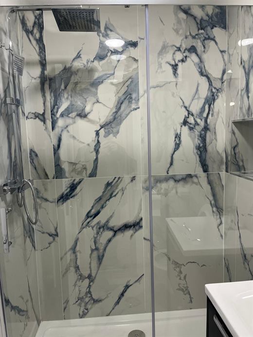 Shower with marble-effect tiles and rain head