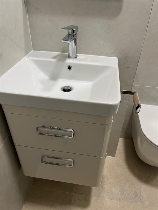 Wall-hung vanity unit with basin and chrome tap