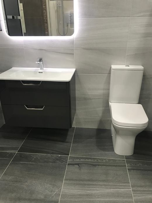 Wall-hung vanity with backlit mirror and grey floor tiles